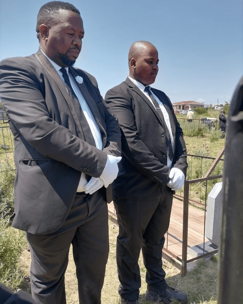Bearded senior man walking near woman with flowers on funeral